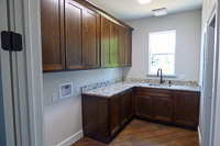 stained red oak custom laundry room cabinets in Valley View Texas
